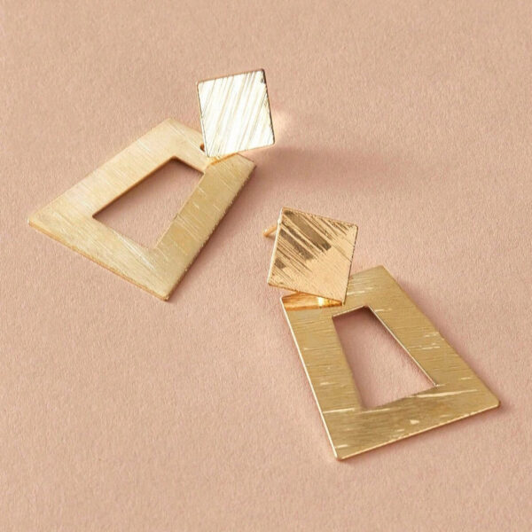 Eclat Newyork's Simple Geometric Earrings with brushed gold-tone squares and diamond shapes, lying on a soft beige background.