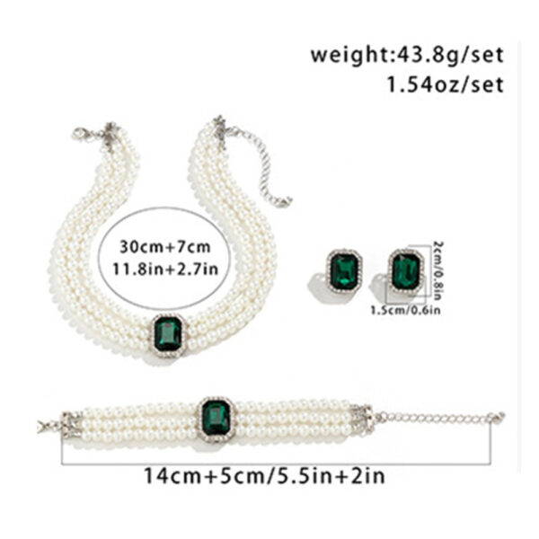 Large green emerald stones adorn this multilayer pearl jewellery set by Eclat New York, which includes a pearl bracelet, matching earrings, and a choker.