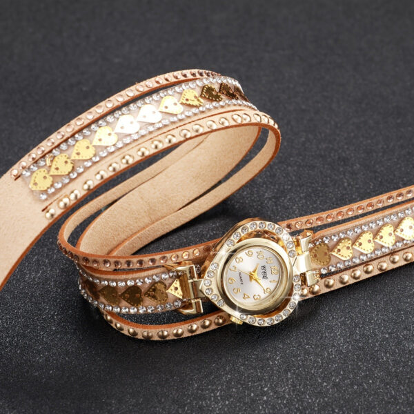 Eclat Newyork Heart-shaped bracelet watch with a Golden wraparound strap, an attractive gold-detailed watch face, and rhinestone and golden heart embellishments.